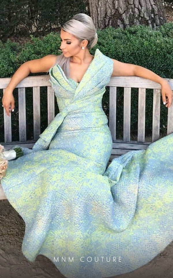 MNM Couture 2425 long mermaid gown with asymmetric neckline and stylized brocade design.| Couture Shop LA