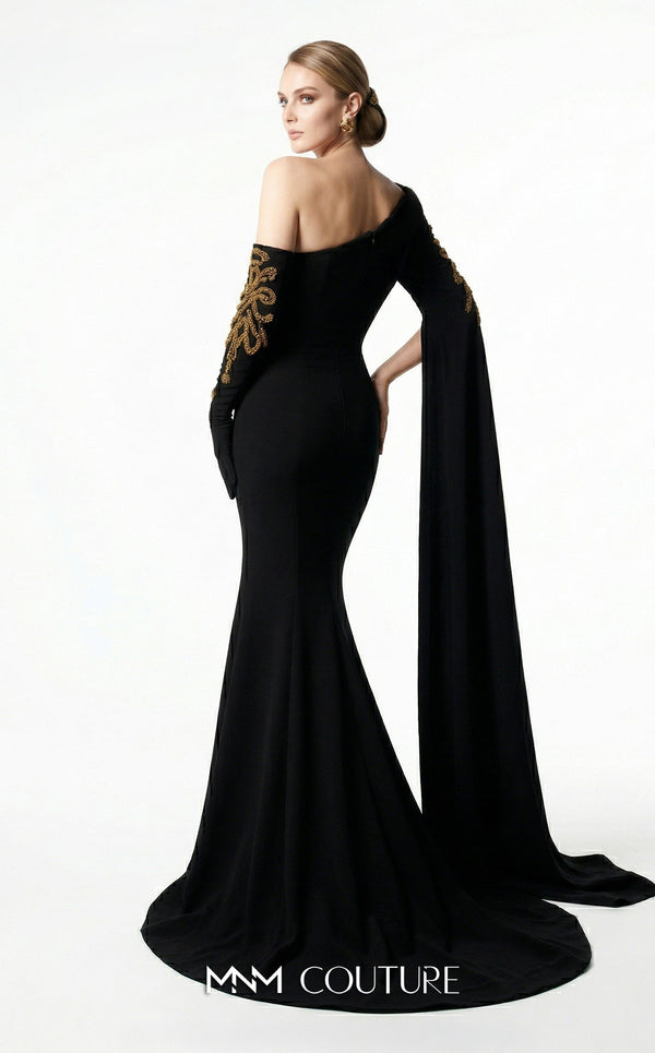 MNM Couture 2606A black stretch crepe off-shoulder mermaid gown with sweetheart neckline, left sheer illusion glove sleeve in gold metallic floral lace, right floor-length crepe cape drape with gold lace, open upper back, and sweep train | Couture Shop LA