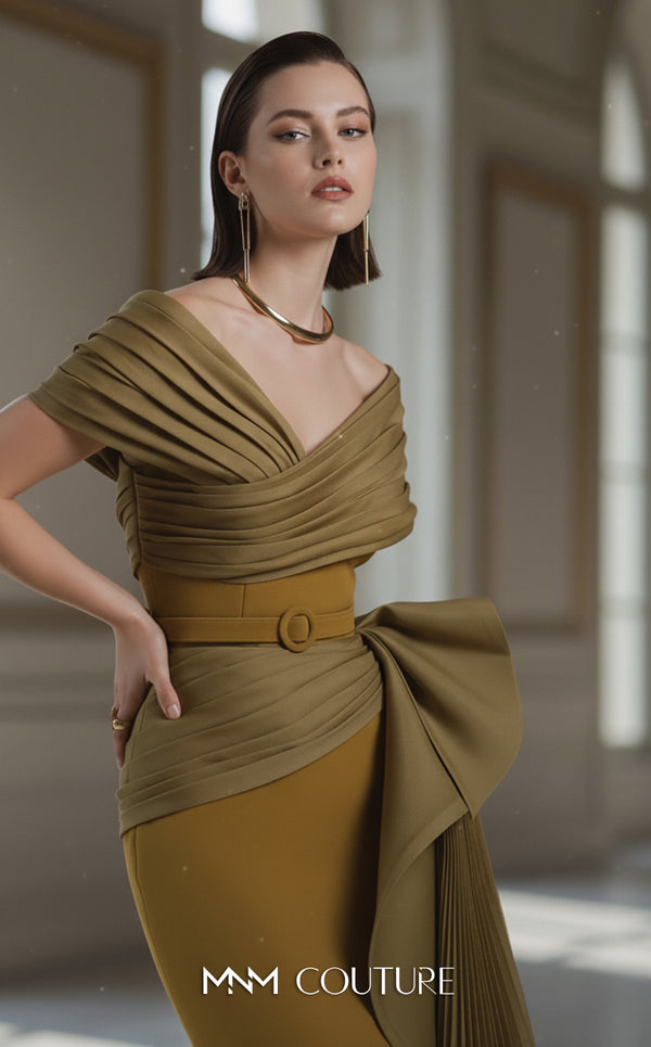A sophisticated MNM Couture 2692 off-shoulder mermaid gown featuring pleated foldover details, ruffled side peplums, and a sweeping train. | Couture Shop LA