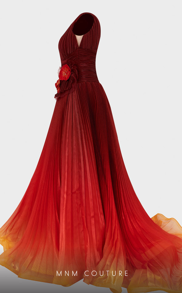 A luxurious MNM Couture 2708 sleeveless A-line gown with an ombre pleated skirt, plunging V-neckline, floral appliqués, and a ruffled V-back with a sweep train. | Couture Shop LA