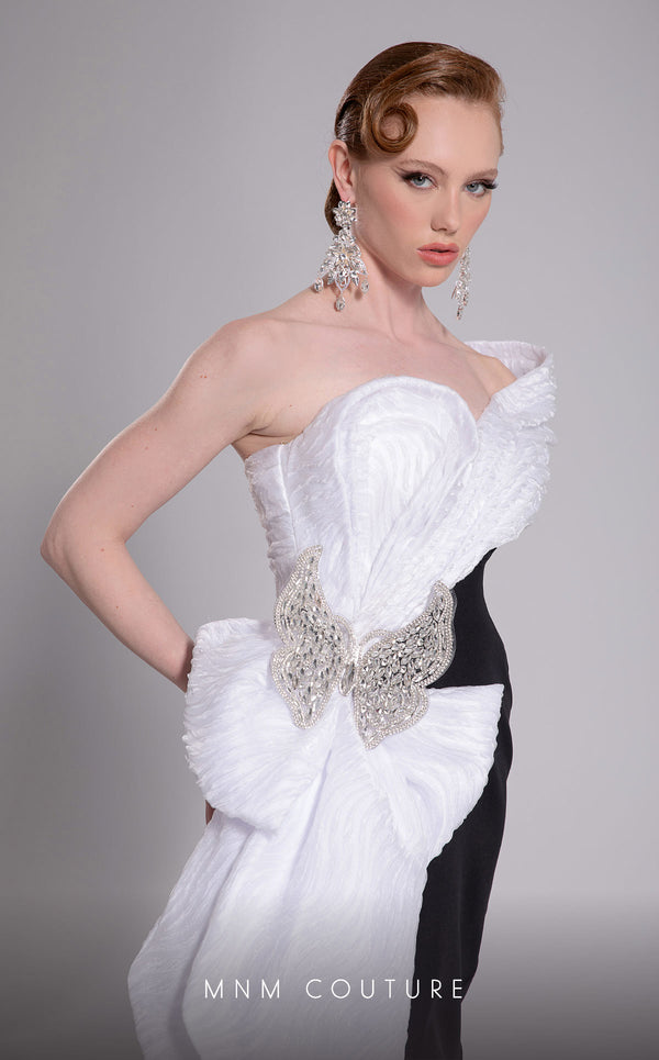 MNM Couture Style F02907 featuring an asymmetric mermaid gown with a large pleated organza bow, one off-shoulder cap sleeve, and crystal embellishments on the bodice. | Couture Shop LA