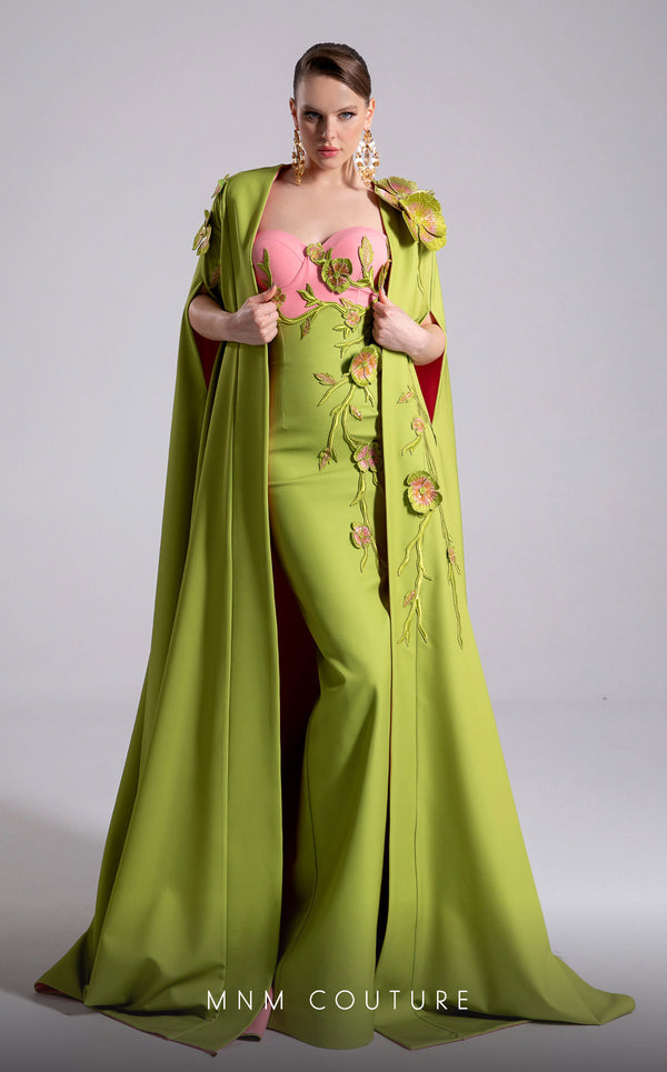MNM Couture Style F02917 showing a fitted green column gown with a pink strapless bustier top, adorned with embroidered floral appliqués, and paired with a matching green cape. | Couture Shop LA
