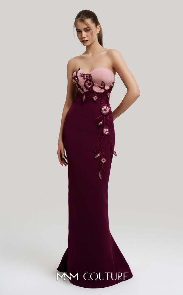 MNM Couture Style F02917 showing a fitted green column gown with a pink strapless bustier top, adorned with embroidered floral appliqués, and paired with a matching green cape. | Couture Shop LA