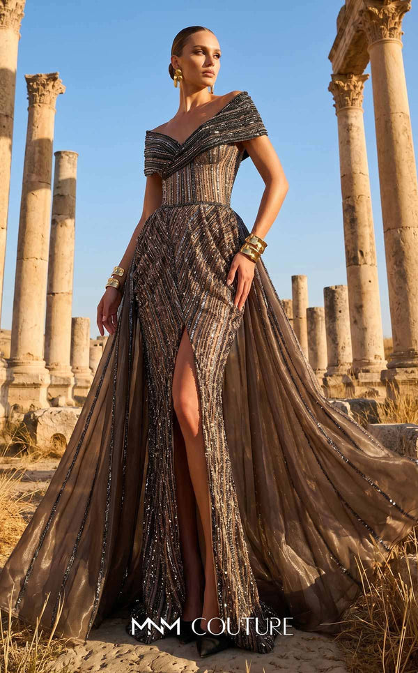 MNM Couture Style F02929 showcasing a dramatic off-the-shoulder A-line gown with dark sequin and bead embellishments and a full, vertically striped tulle overlay. | Couture Shop LA