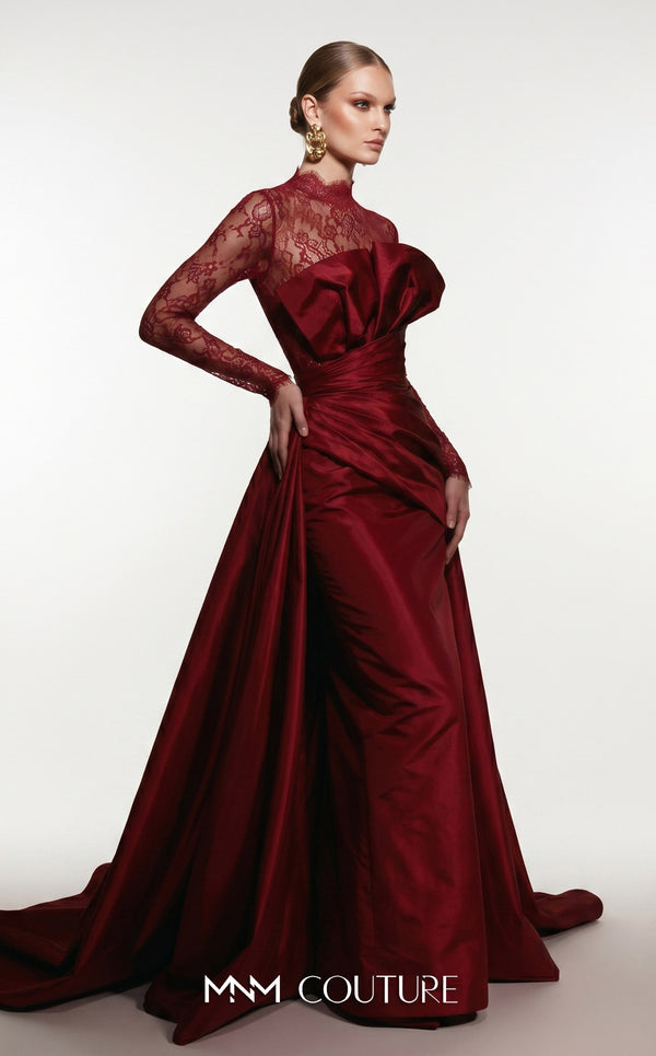 MNM Couture F03006A Chantilly lace and satin column gown featuring a high lace collar, sheer long sleeves, a 3D shoulder bow, an asymmetric ruched waist belt, stomach draping, and an open-front A-line overskirt | Couture Shop LA