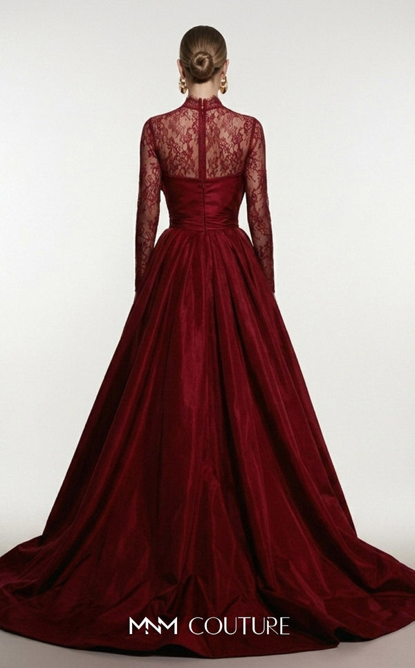 MNM Couture F03006A Chantilly lace and satin column gown featuring a high lace collar, sheer long sleeves, a 3D shoulder bow, an asymmetric ruched waist belt, stomach draping, and an open-front A-line overskirt | Couture Shop LA