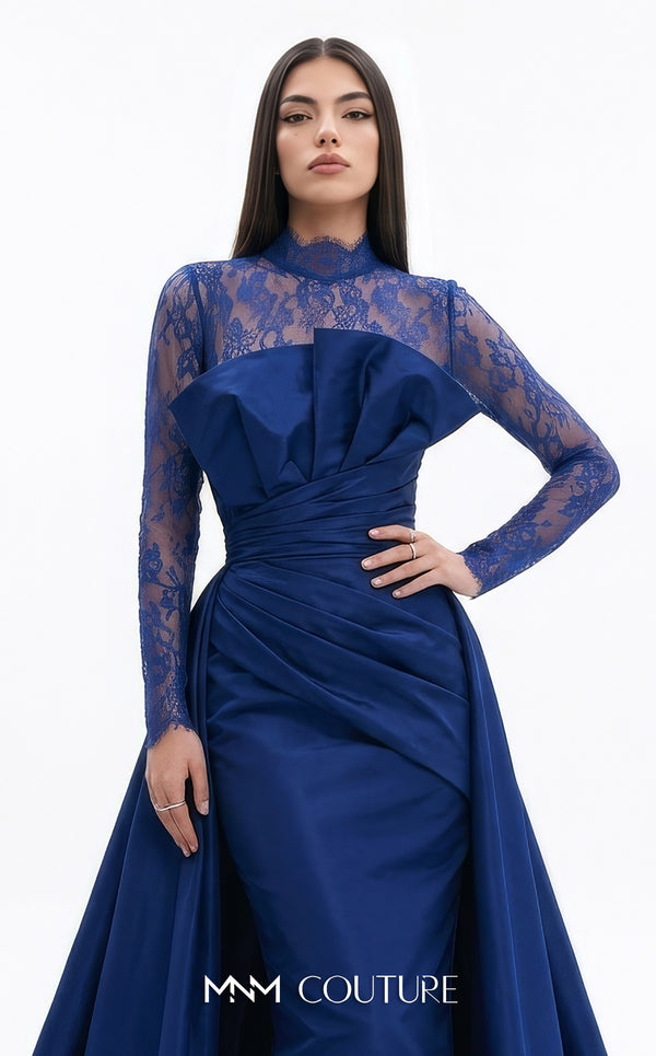 MNM Couture F03006A Chantilly lace and satin column gown featuring a high lace collar, sheer long sleeves, a 3D shoulder bow, an asymmetric ruched waist belt, stomach draping, and an open-front A-line overskirt | Couture Shop LA