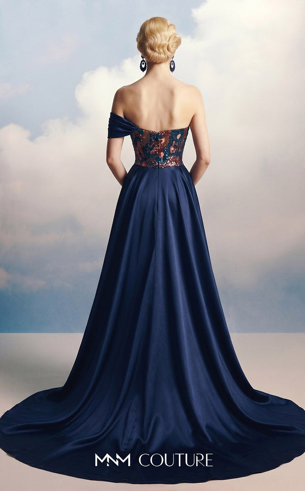 MNM Couture F03044 navy duchess satin gown with diagonal off-shoulder drape, sculptural right-shoulder petal, multicolor sequin-embroidered column, open-front A-line overskirt, and open back | Couture Shop LA.