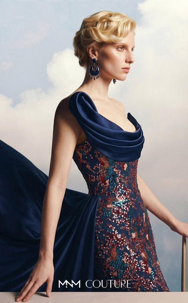 MNM Couture F03044 navy duchess satin gown with diagonal off-shoulder drape, sculptural right-shoulder petal, multicolor sequin-embroidered column, open-front A-line overskirt, and open back | Couture Shop LA.