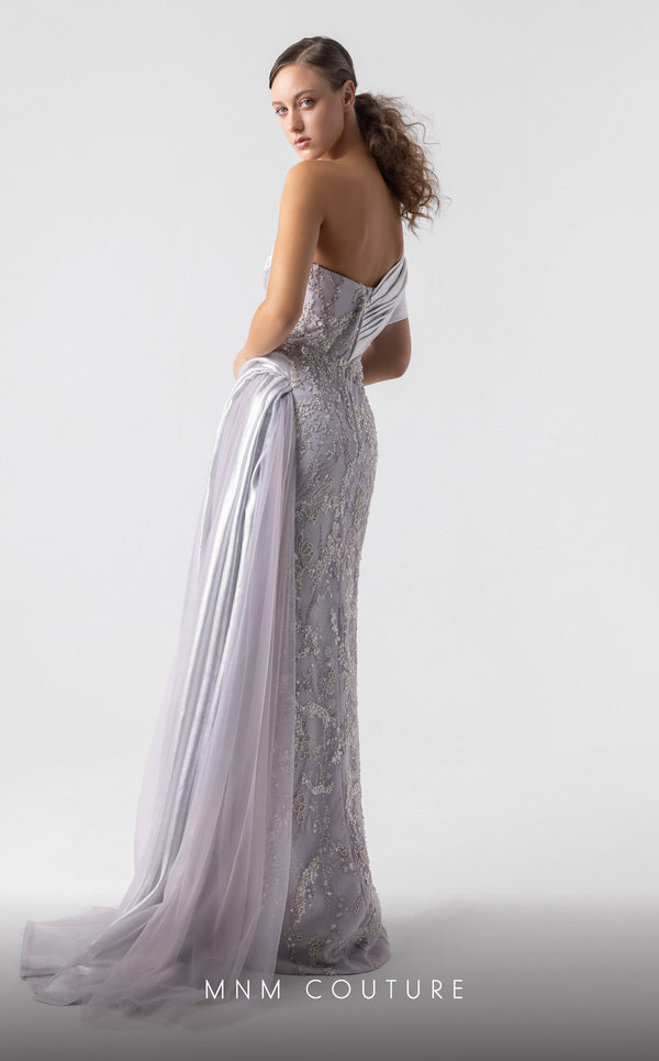 MNM Couture G1932 silver draped gown with off-shoulder design and high slit for evening elegance. | Couture Shop LA