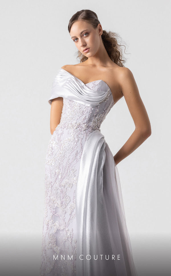 MNM Couture G1932 silver draped gown with off-shoulder design and high slit for evening elegance. | Couture Shop LA