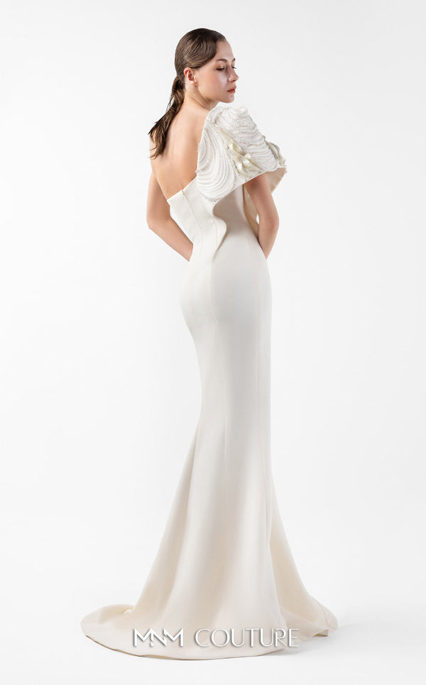 MNM Couture Style G2003 showcasing a cream one-shoulder mermaid gown with sculptural organza manipulation and cascading pearl embroidery on the shoulder. | Couture Shop LA