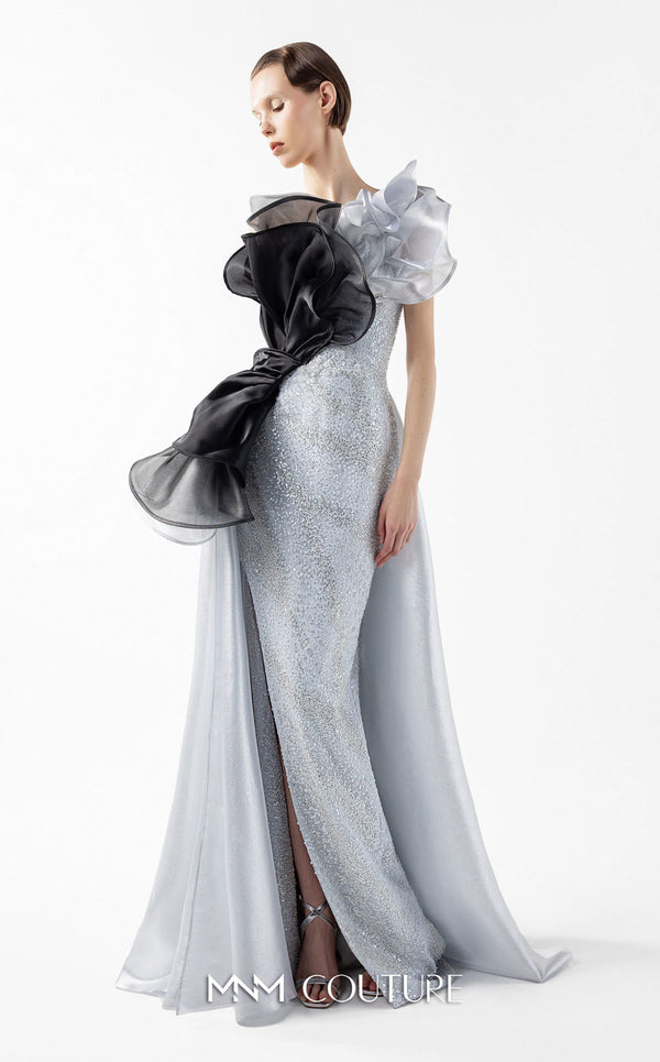 MNM Couture Style G2042 showcasing a silver lace gown with sculptural black and silver lamé organza ruffles, one-shoulder detail, and a high slit. | Couture Shop LA