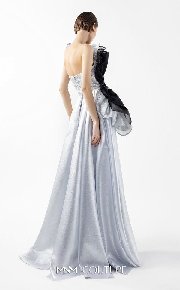 MNM Couture Style G2042 showcasing a silver lace gown with sculptural black and silver lamé organza ruffles, one-shoulder detail, and a high slit. | Couture Shop LA