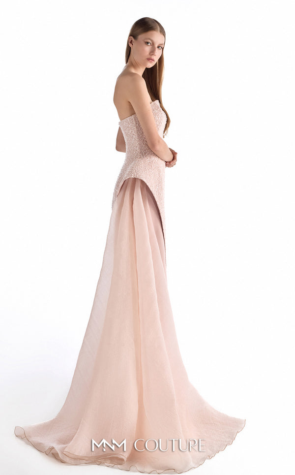 MNM Couture G2223 blush lace, crepe, and organza strapless column gown with intricate all-over embellishment, sculptural asymmetric peplum, and flowing organza overskirt with floor-length train | Couture Shop LA.