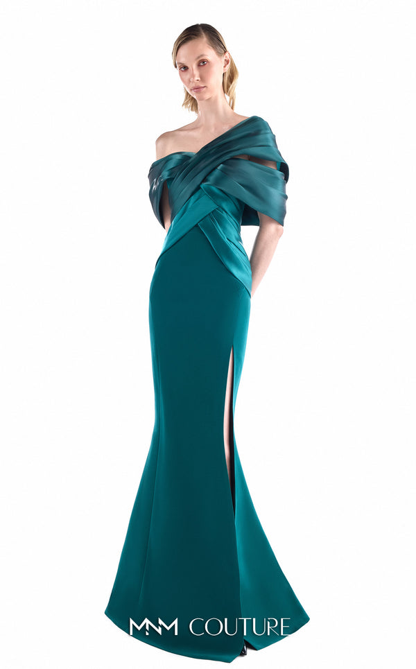 MNM Couture G2241 emerald green crepe mermaid gown with large multi-layered sculptural satin bow at center upper back, satin wing panels draped over both shoulders into a V-wrap off-shoulder bodice, open bare back, and thigh-high left front slit | Couture Shop LA