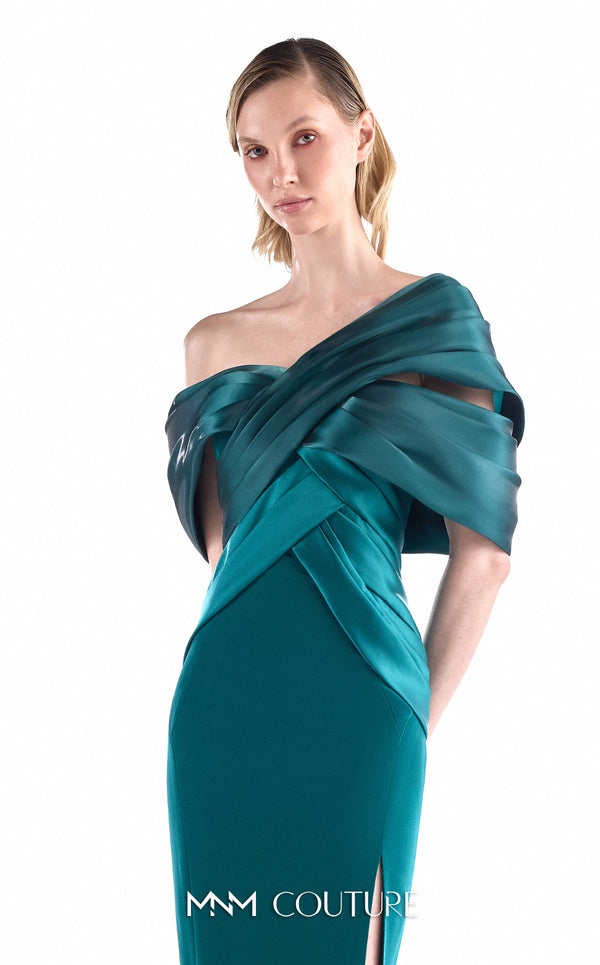 MNM Couture G2241 emerald green crepe mermaid gown with large multi-layered sculptural satin bow at center upper back, satin wing panels draped over both shoulders into a V-wrap off-shoulder bodice, open bare back, and thigh-high left front slit | Couture Shop LA