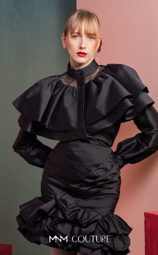 MNM Couture GOF2539 two-piece ensemble in black taffeta, featuring a dramatic ruffled blouse with sheer neckline accents and a matching ruched skirt with a ruffled hem. | Couture Shop LA