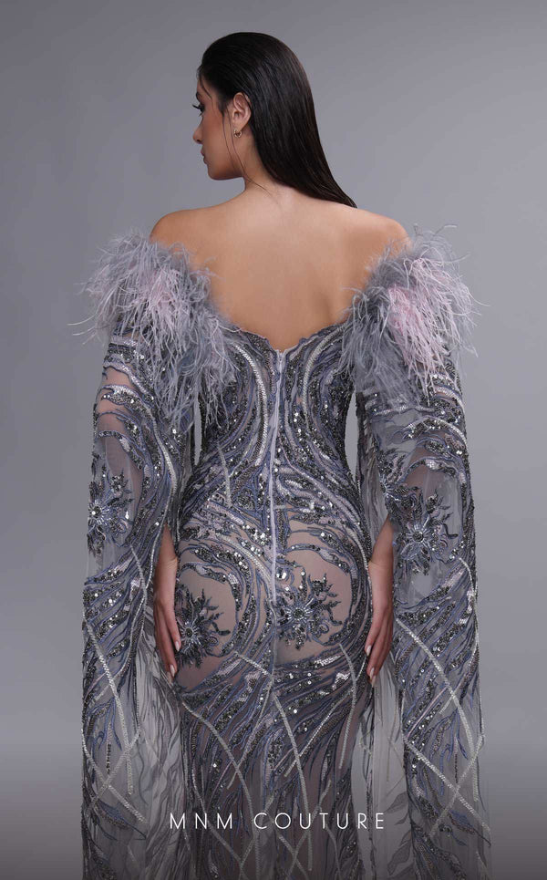 MNM Couture K4097 mermaid gown with sheer cape sleeves, feather details, and intricate beaded motifs. | Couture Shop LA