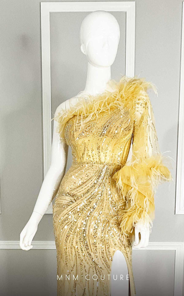MNM Couture M1073 asymmetric column gown with one long sleeve, sequin and bead embroidery, plumage on the neckline, and a thigh-high slit. | Couture Shop LA