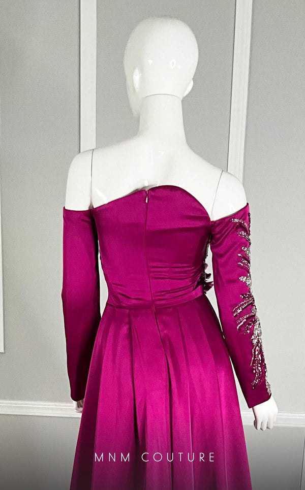 MNM Couture M1104 Fitted satin� off-shoulder gown adorned with� sequins� and� beads� in a flowery pattern with long sleeves, asymmetrical neckline, and high side slit. | Couture Shop LA