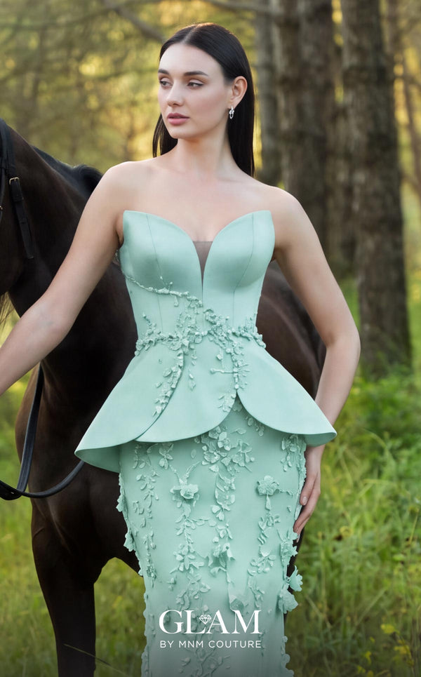 MNM Couture O07909 black strapless gown with illusion sweetheart neckline, crystal beaded waist vine, petal peplum panels, and fitted tulle skirt with 3D floral appliqués | Couture Shop LA