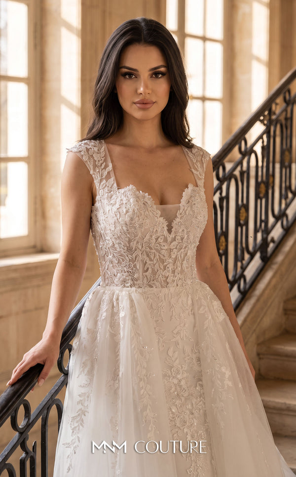 MNM Couture W2305 white lace mermaid wedding dress with illusion sweetheart neckline, structured lace shoulder straps, open U back, 3D floral appliqués at the knee flare, and floor-length tulle overlay overskirt with trailing train | Couture Shop LA