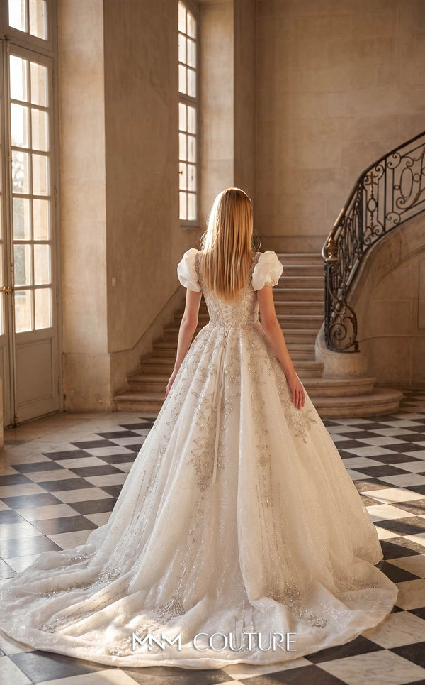 MNM Couture W2312 white sweetheart ball gown wedding dress with short structured puff sleeves, diagonal swirling crystal-beaded bodice with center medallion, low open corset back, and voluminous tulle skirt with swirling lace appliqués and cathedral train | Couture Shop LA