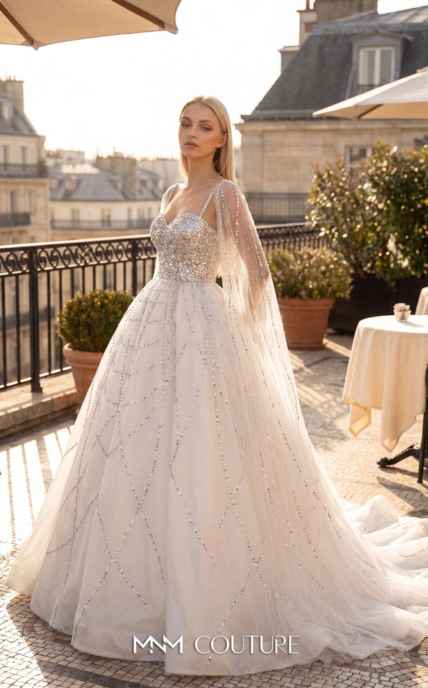 MNM Couture W2322 white ball gown wedding dress with ultra-dense crystal-beaded sweetheart bodice, illusion straps, floor-length sheer cape sleeves, low open square back, scattered crystal tulle skirt, and front-open overskirt with cathedral train | Couture Shop LA