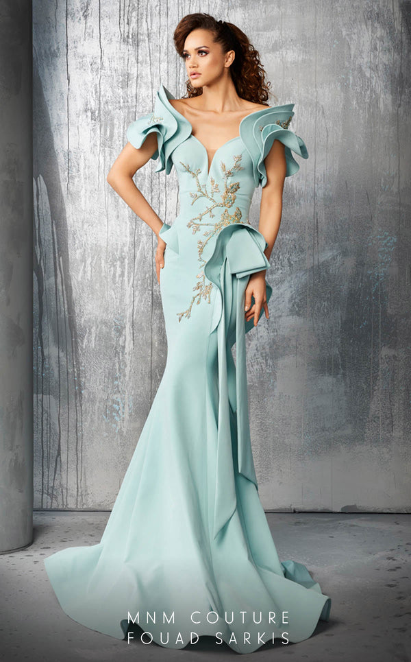 An exquisite MNM Couture 2670 mermaid gown with intricate beading, layered illusion-inset sleeves, peplum accents, and a cascading bow detail. | Couture Shop LA