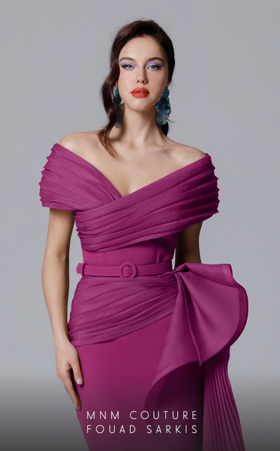 A sophisticated MNM Couture 2692 off-shoulder mermaid gown featuring pleated foldover details, ruffled side peplums, and a sweeping train. | Couture Shop LA