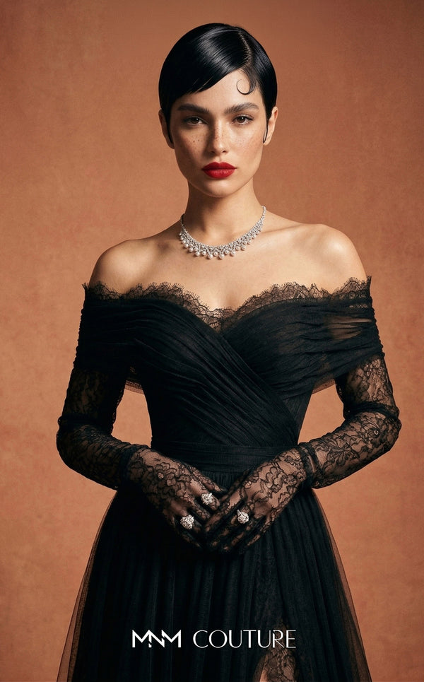 MNM Couture Style B1141 featuring a flared black organza gown with an off-the-shoulder sweetheart neckline, long sleeves, and a long, flowing train cape at the back.| Couture Shop LA.