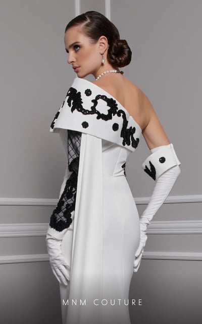 Elegant MNM Couture F02803 evening gown featuring a strapless, off-shoulder design with a single long sleeve, adorned with intricate beading and tassels | Couture Shop LA