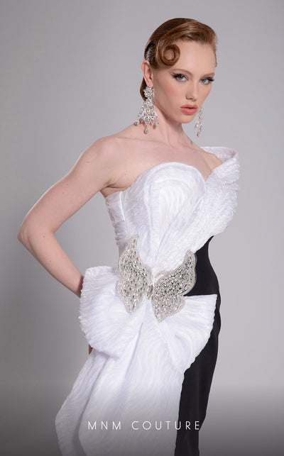 MNM Couture Style F02907 featuring an asymmetric mermaid gown with a large pleated organza bow, one off-shoulder cap sleeve, and crystal embellishments on the bodice. | Couture Shop LA