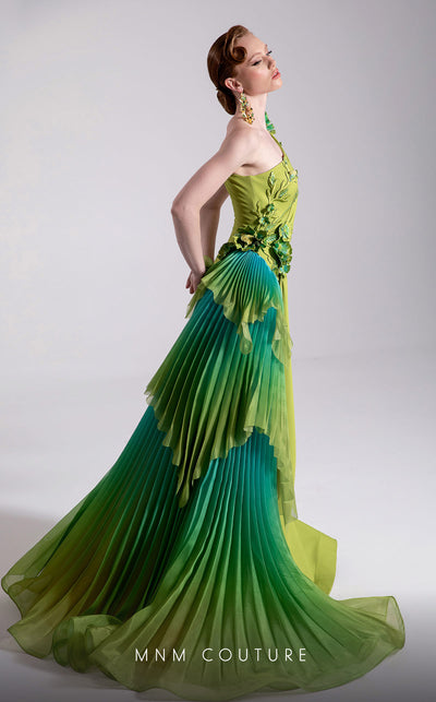 MNM Couture Style F02911 one-shoulder green gown with a draped bodice, floral appliqués at shoulder and hip, and a large pleated ombre ruffle train. | Couture Shop LA