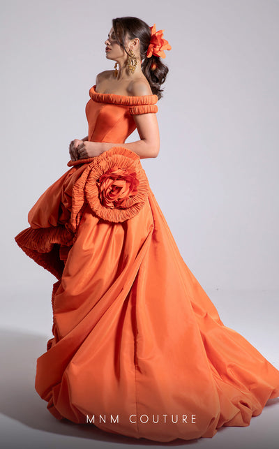 MNM Couture Style F02913 featuring an orange taffeta dress with off-shoulder cap sleeves, drapery on the neckline and waist, a high-low skirt with a cascading train, and a floral accent. | MNM Couture.