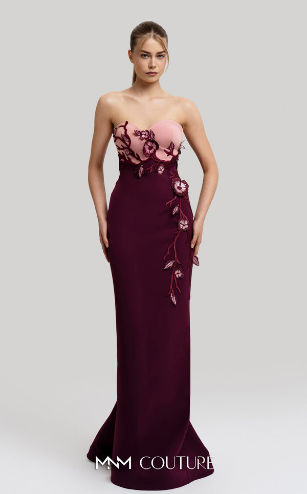 MNM Couture Style F02917 showing a fitted green column gown with a pink strapless bustier top, adorned with embroidered floral appliqués, and paired with a matching green cape. | Couture Shop LA
