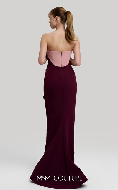 MNM Couture Style F02917 showing a fitted green column gown with a pink strapless bustier top, adorned with embroidered floral appliqués, and paired with a matching green cape. | Couture Shop LA