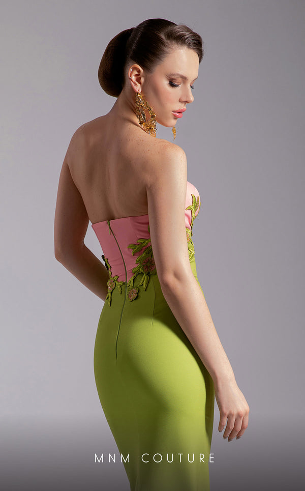 MNM Couture Style F02917 showing a fitted green column gown with a pink strapless bustier top, adorned with embroidered floral appliqués, and paired with a matching green cape. | Couture Shop LA