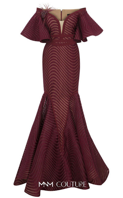 MNM Couture Style F02925 - Elegant black mesh mermaid gown featuring off-shoulder ruffled bell sleeves, a deep V-neckline, and a plumage brooch. | Couture Shop LA
