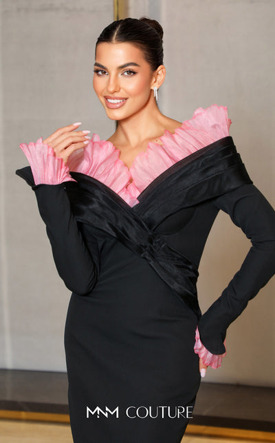 MNM Couture Style F02941 showing a black form-fitting evening gown with a pink off-the-shoulder ruffle detail, matching ruffled cuffs on the long sleeves, and a high back slit. | Couture Shop LA