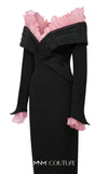 MNM Couture Style F02941 showing a black form-fitting evening gown with a pink off-the-shoulder ruffle detail, matching ruffled cuffs on the long sleeves, and a high back slit. | Couture Shop LA