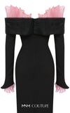 MNM Couture Style F02941 showing a black form-fitting evening gown with a pink off-the-shoulder ruffle detail, matching ruffled cuffs on the long sleeves, and a high back slit. | Couture Shop LA
