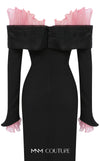 MNM Couture Style F02941 showing a black form-fitting evening gown with a pink off-the-shoulder ruffle detail, matching ruffled cuffs on the long sleeves, and a high back slit. | Couture Shop LA