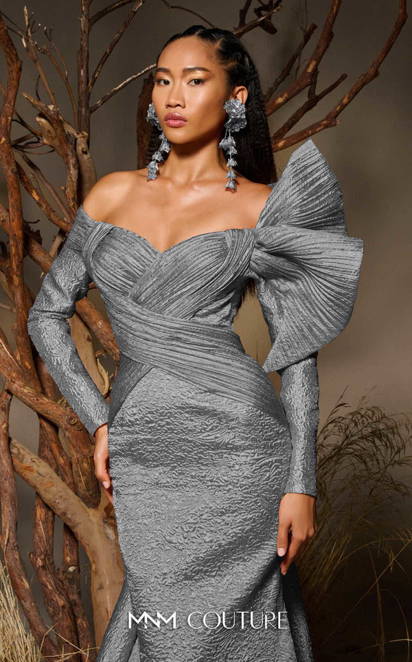 MNM Couture F02982 textured jacquard gown with off-the-shoulder long sleeves, pleated fans on the left shoulder, and a dramatic back train.|Couture Shop LA