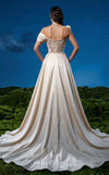 MNM Couture F03044 navy duchess satin gown with diagonal off-shoulder drape, sculptural right-shoulder petal, multicolor sequin-embroidered column, open-front A-line overskirt, and open back | Couture Shop LA.