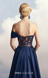MNM Couture F03044 navy duchess satin gown with diagonal off-shoulder drape, sculptural right-shoulder petal, multicolor sequin-embroidered column, open-front A-line overskirt, and open back | Couture Shop LA.
