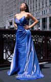 A glamorous MNM Couture G1419 metallic sheath gown featuring a strapless pleated bodice, faux-wrap design, pointed neckline, and a dramatic overskirt. | Couture Shop LA