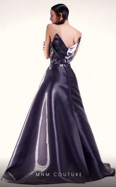 A glamorous MNM Couture G1419 metallic sheath gown featuring a strapless pleated bodice, faux-wrap design, pointed neckline, and a dramatic overskirt. | Couture Shop LA