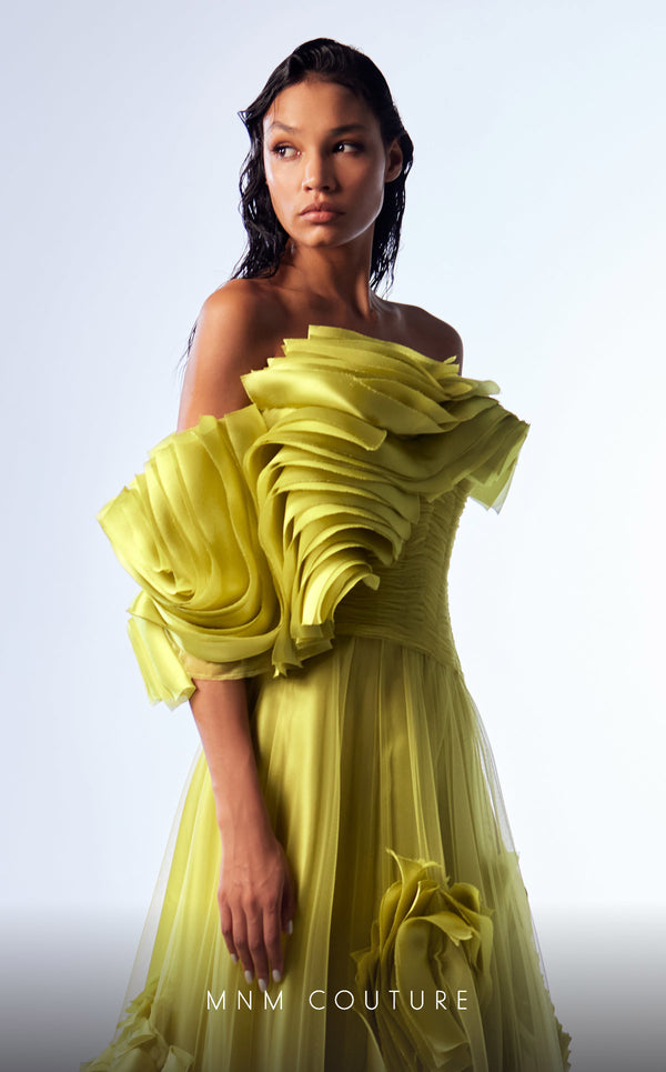 Green organza A-line evening gown with satin ruffles, structured corset bodice, and one off-the-shoulder sleeve highlighting MNM Couture Style G1736 | Couture Shop LA.